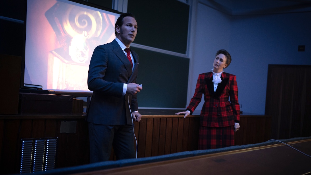 patrick wilson and vera farmiga standing at a pew