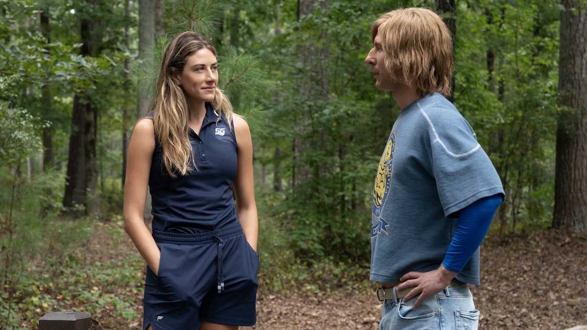 two people standing in the woods