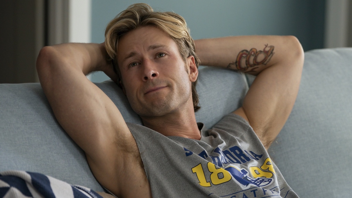 glen powell sitting on a couch