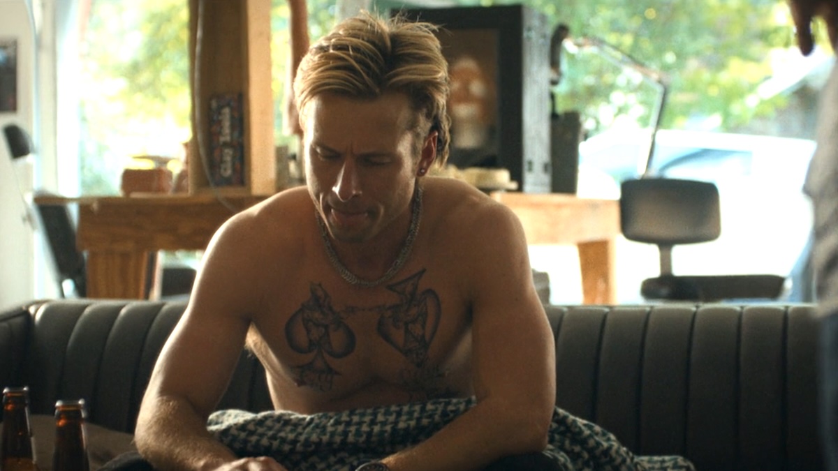 glen powell sitting on a couch
