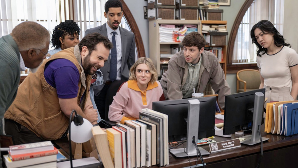 a bunch of people around a computer