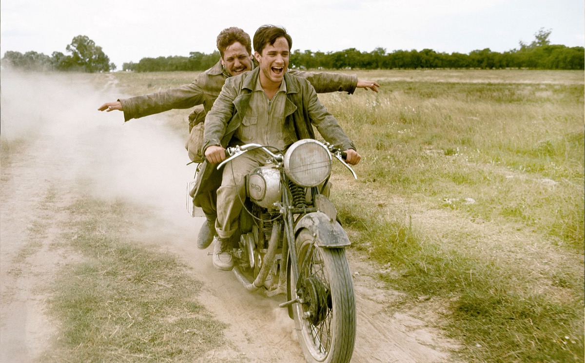 Two men joyfully ride a motorcycle in "Motorcycle Diaries" 