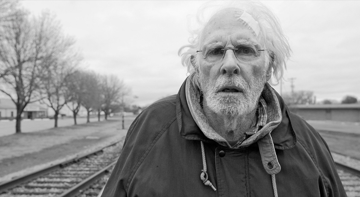 A tired elderly man stands on train tracks in "Nebraska" 