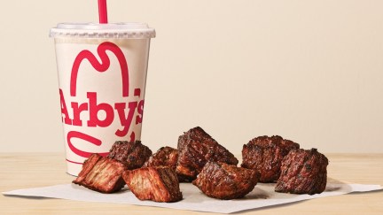 a cup and some pieces of steak