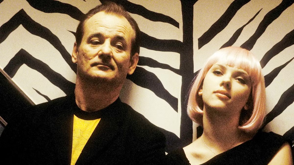 A middle aged man and a young woman sit next to each other contentedly in "Lost In Translation"
