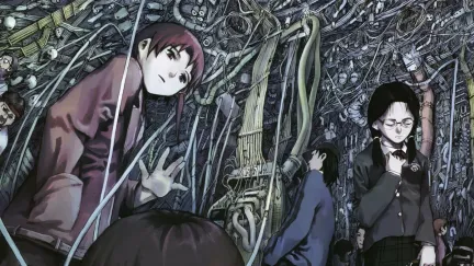 A group of middle schoolers stand in a room full of computer wires in 