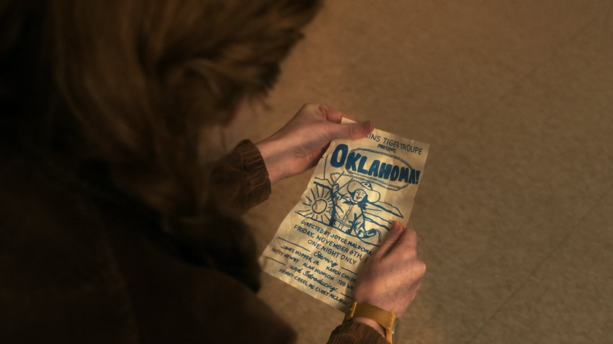 Max holds a flyer for Oklahoma on Stranger Things
