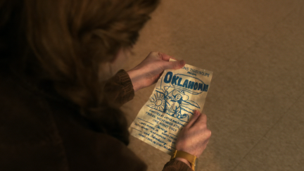 Max holds a flyer for Oklahoma on Stranger Things