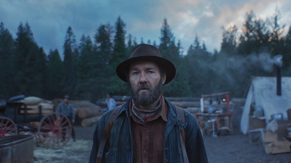 joel edgerton standing in front of trees