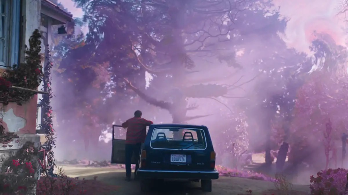 A man stands next to a car looking out at an eerie landscape in "The Colour Out of Space"