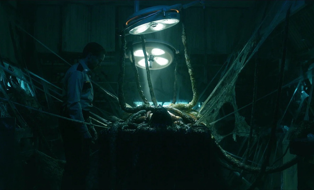 A man looks at a corpse full of tentacles in "The Void"