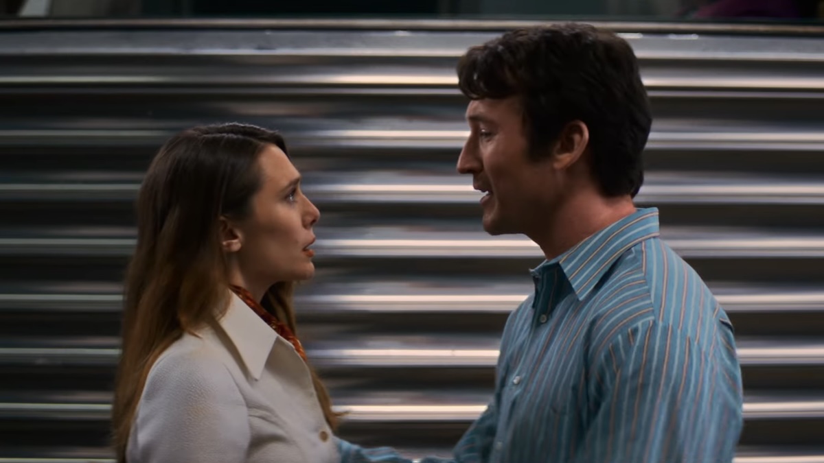 two people standing at a train