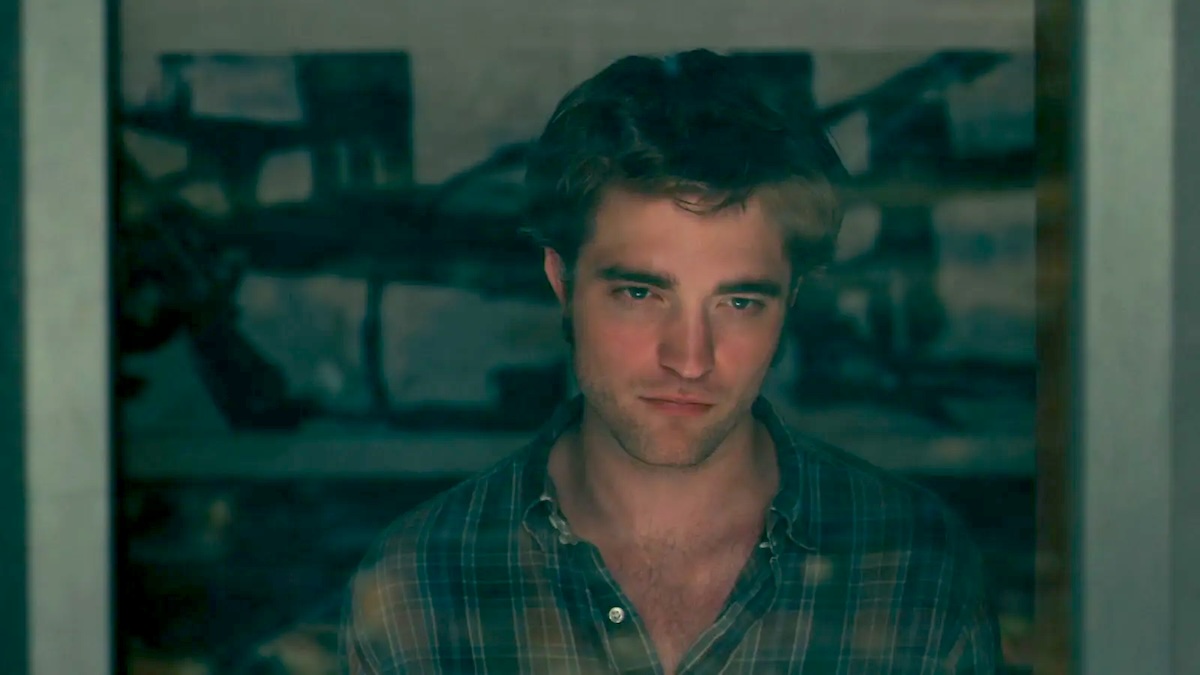 Robert Pattinson standing in a window in remember me