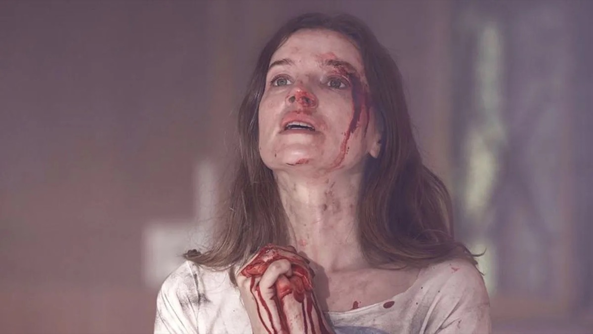 A bloodied woman folds her hands in prayer in "A Dark Song" 