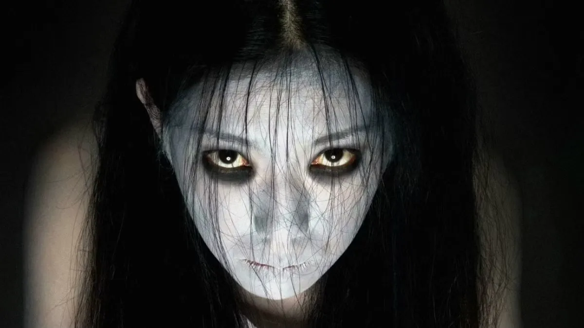 A ghostly woman glares at the camera in "Ju-On: The Grudge"