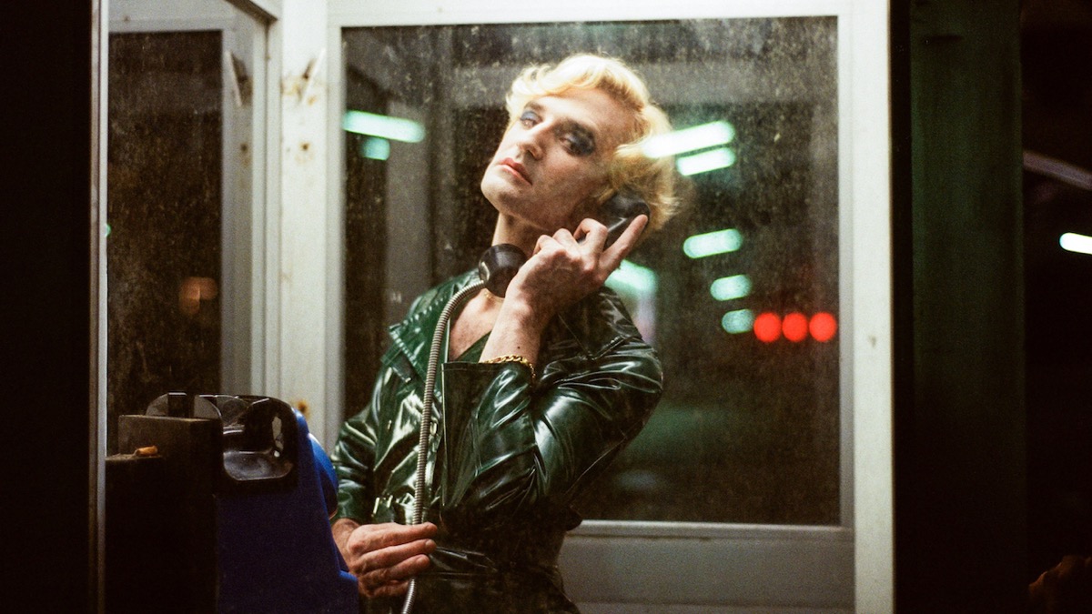 A person stands in a telephone booth in "Knife + Heart" 