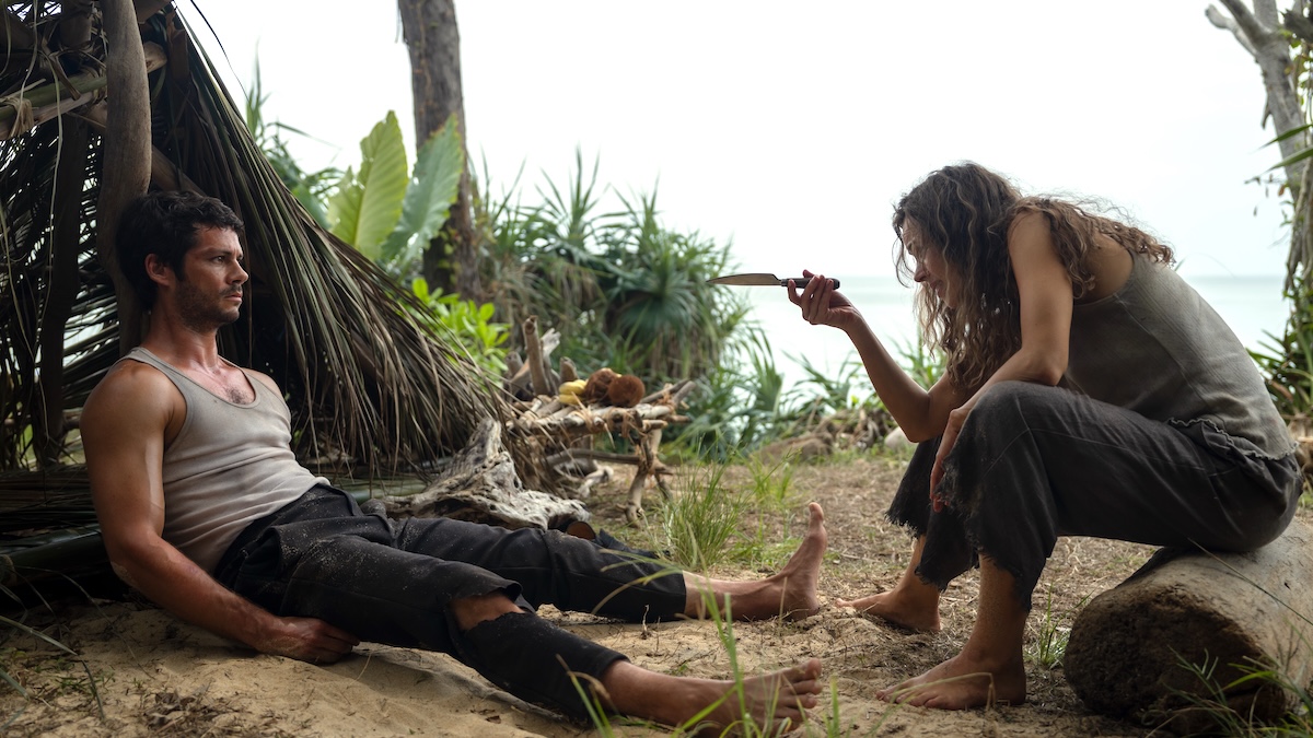two people sitting on a beach