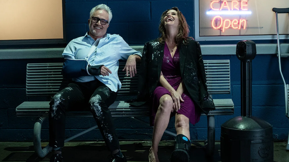 Bradley Whitford and Amy Landecker sit on a bench in For Worse