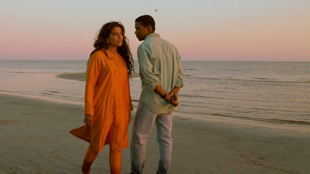 A man and a woman walk down a beach in "Mississippi Masala"