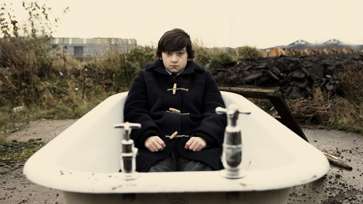 A high school boy sits sullen on a beach in "Submarine"