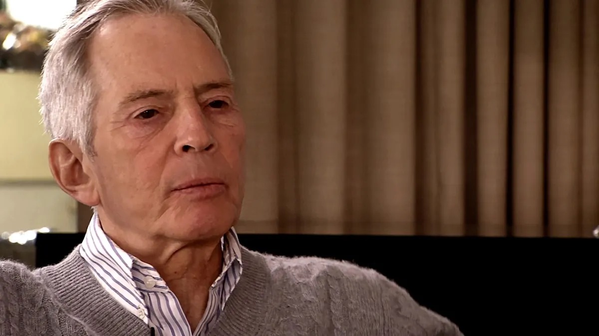 Serial killer Robert Durst sits with a cold look on his face in "The Jinx"