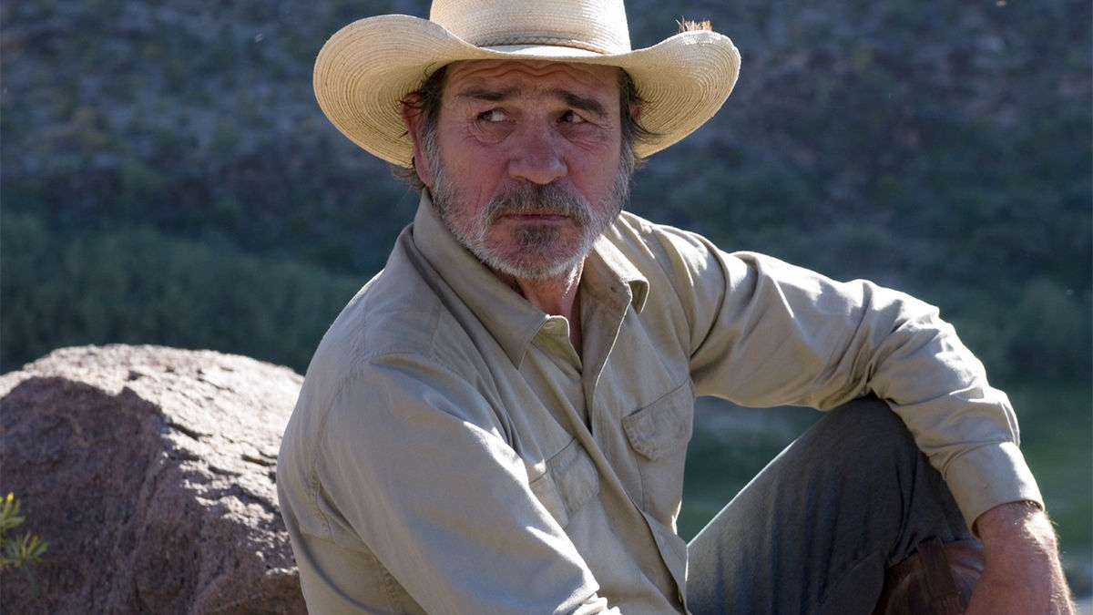 A man in a cowboy hat sits on a rock in "Three Burials of Melquiades Estrada"