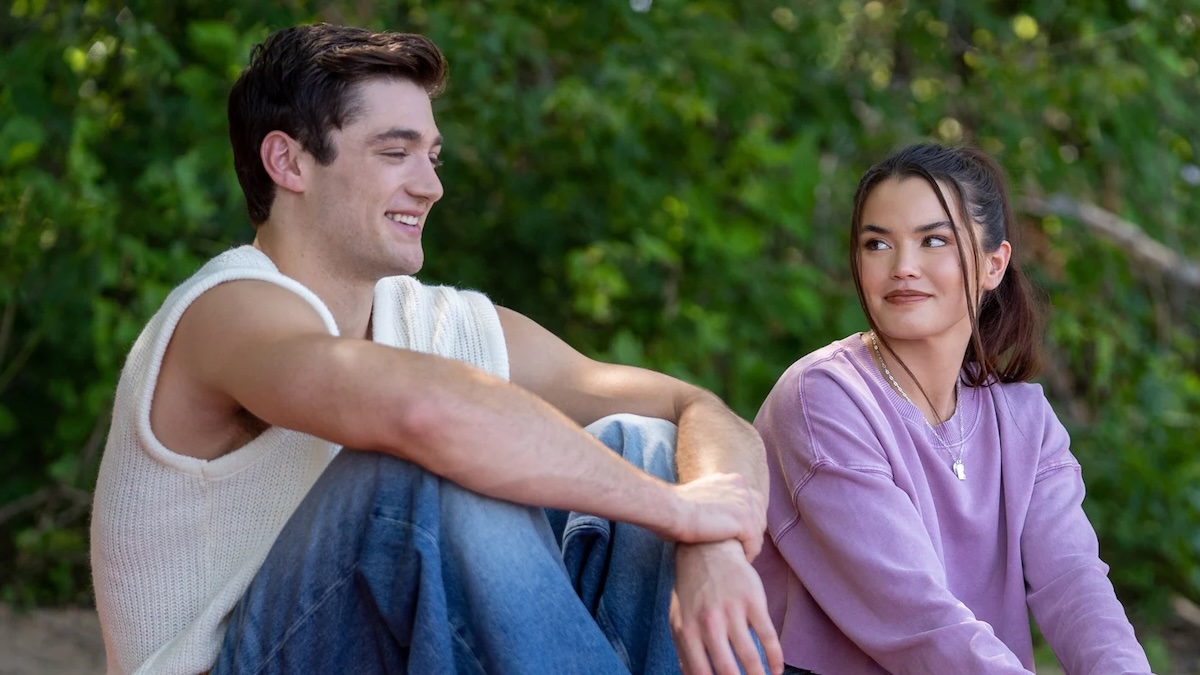 two people sitting on a beach