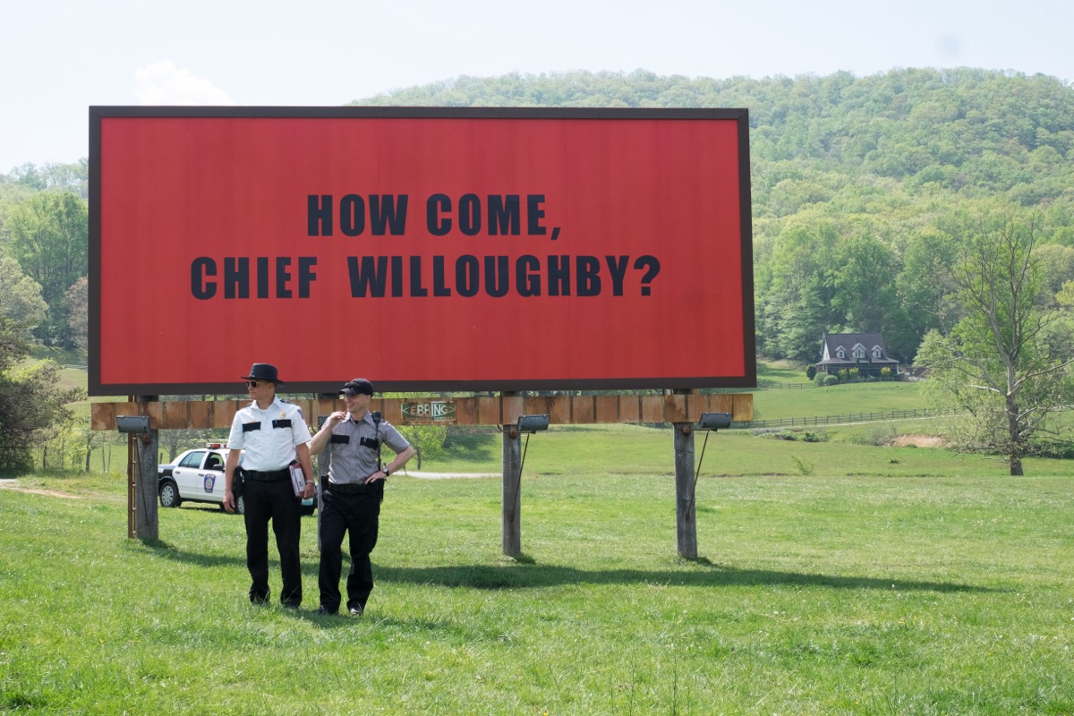 Two cops stand in front of a billoard in "Three Billboards Outside Ebbing, Missouri"