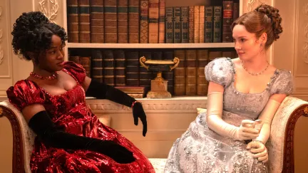 bridgerton couple sitting on a couch