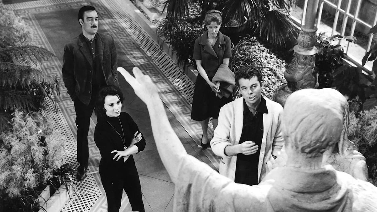 A group of four stands before a statue in "The Haunting"