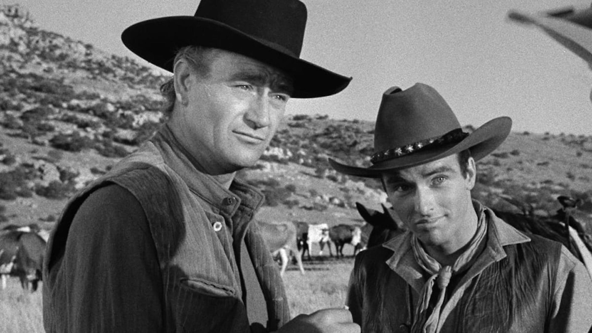 Two cowboys look curiously in the desert in "Red River"