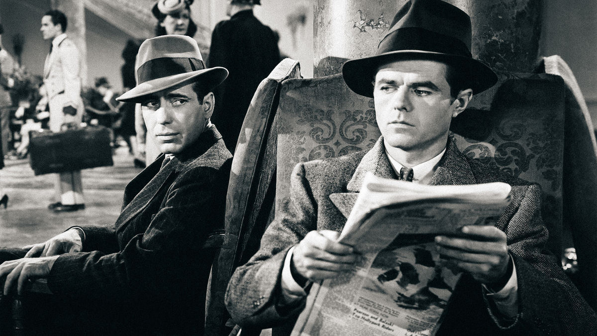 Two men in a lobby side eye each other suspiciously in "The Maltese Falcon"