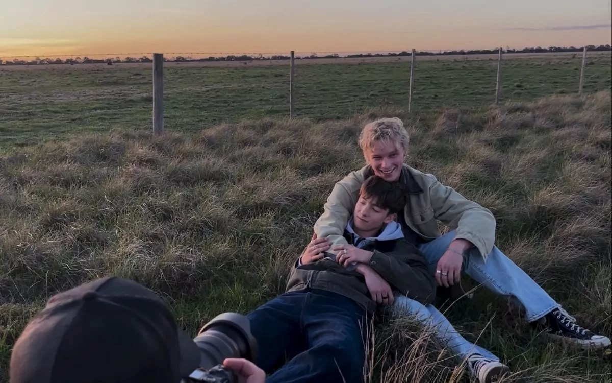 "Two teenage boys cuddle in a field in Leviticus"