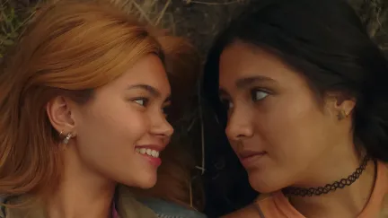 Two teenage girls look longingly at each other in 