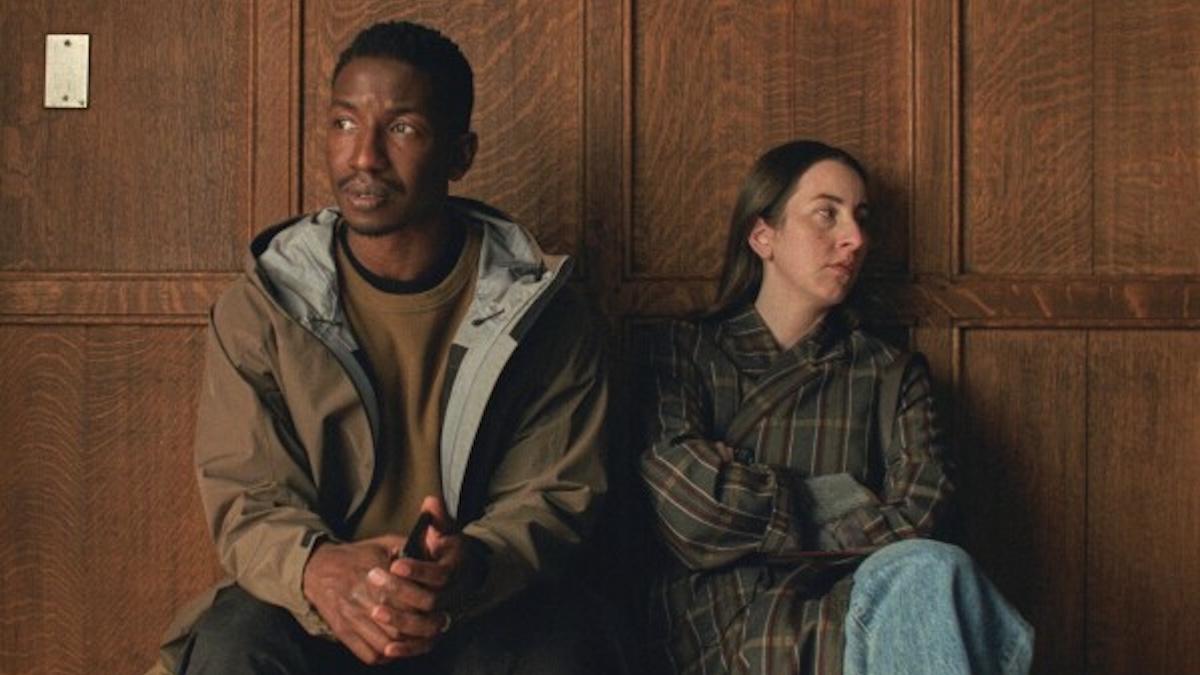 two people sitting against a wall