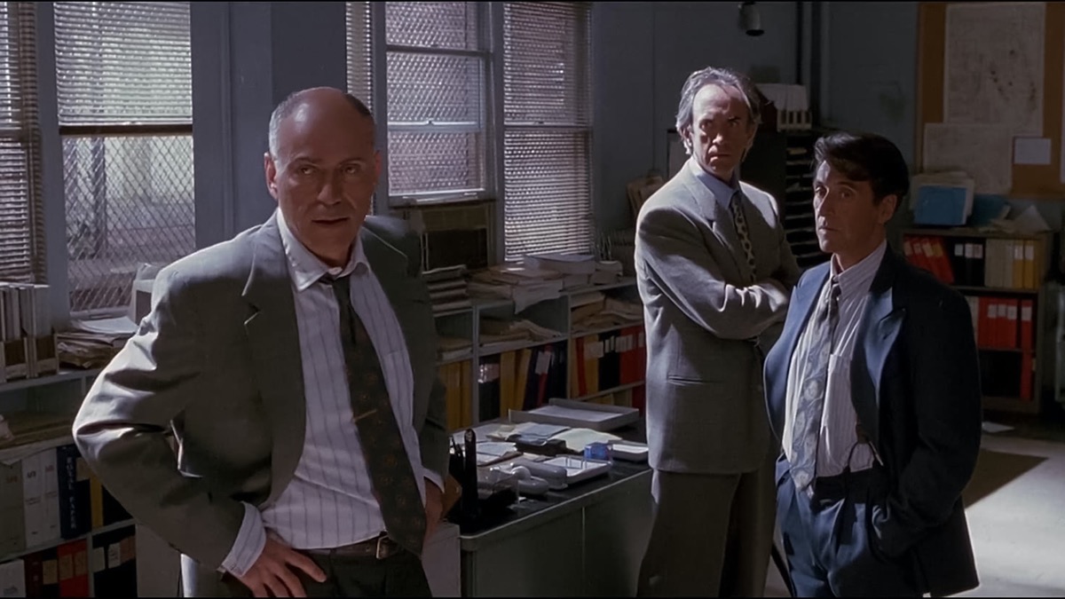 A group of surly men stand in an office in Glengarry Glen Ross