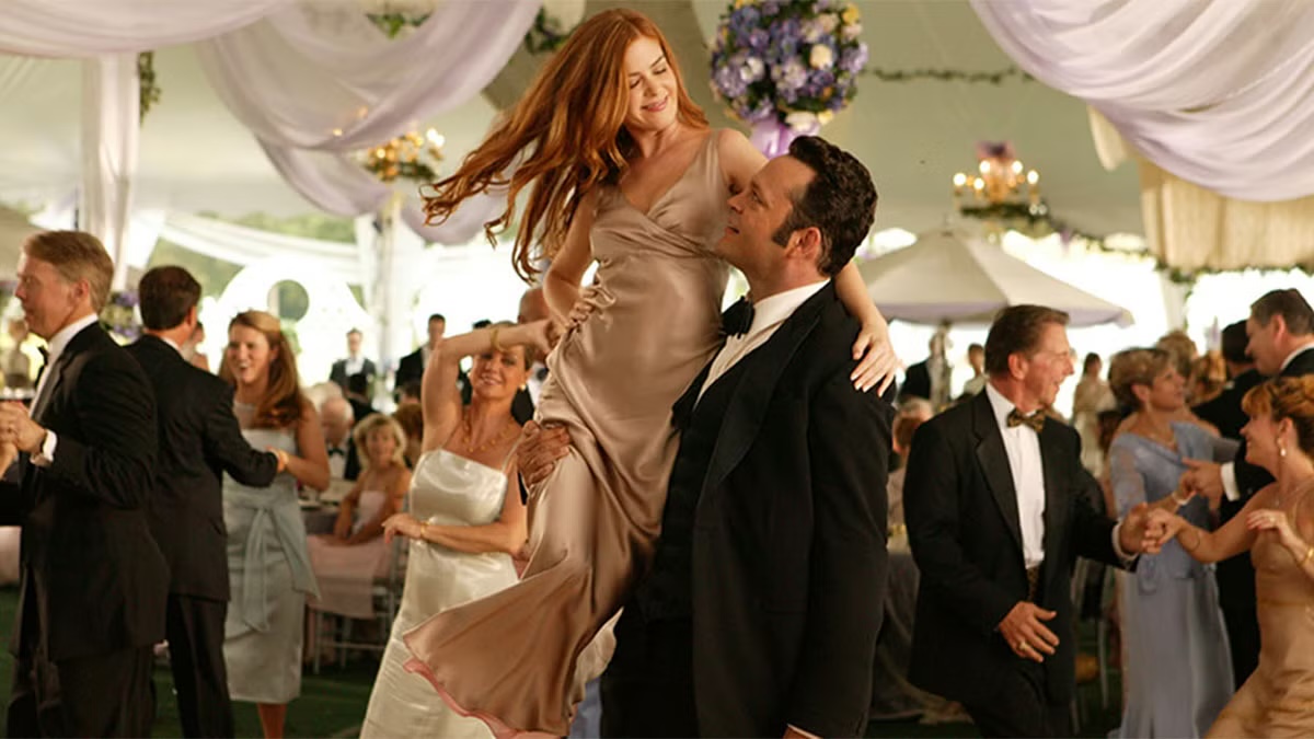 A tuxedoed man lifts a woman up at wedding reception in Wedding Crashers