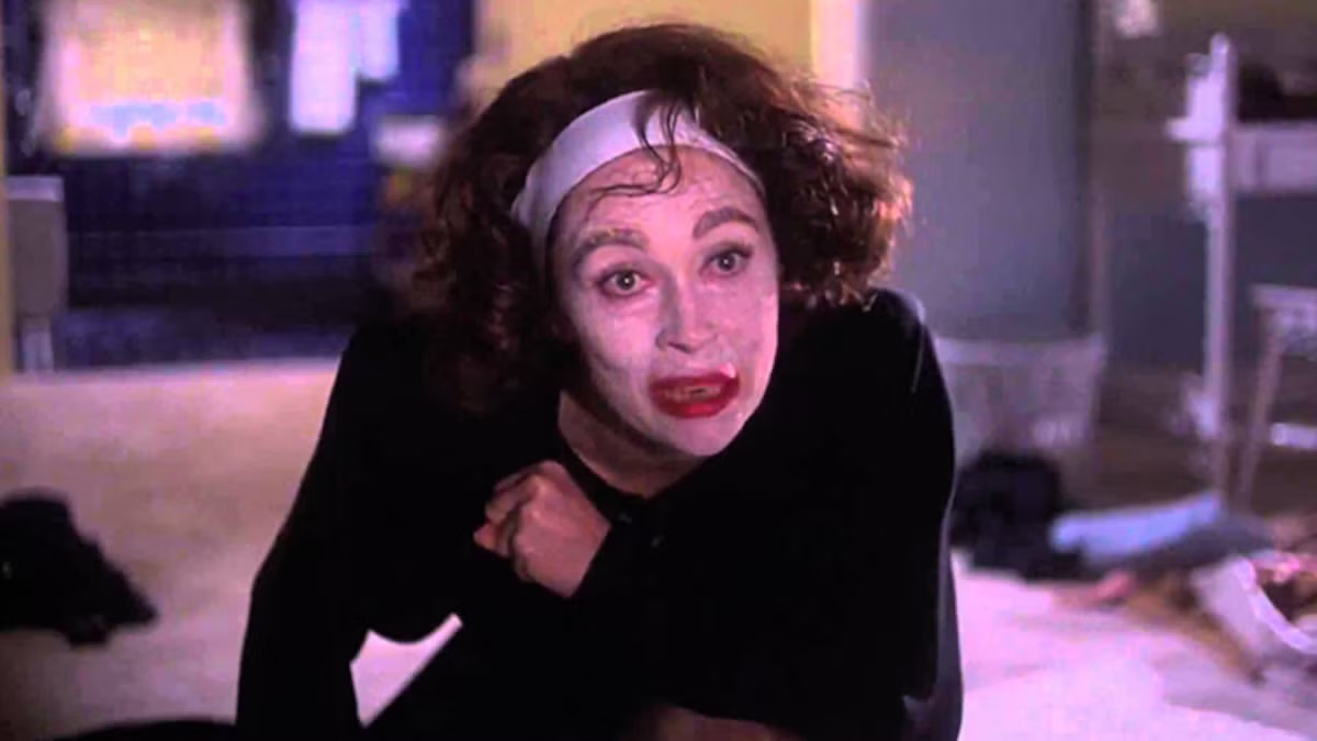 A woman crawls on the ground looking deranged in Mommie Dearest