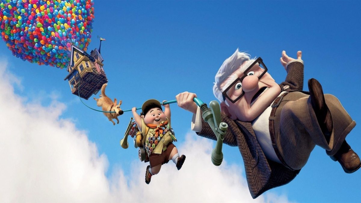 An old man and a young boy float through the sky on balloons in "Up"