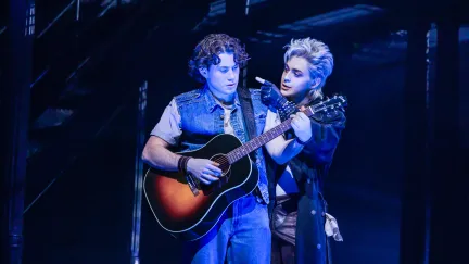 two men on stage with a guitar