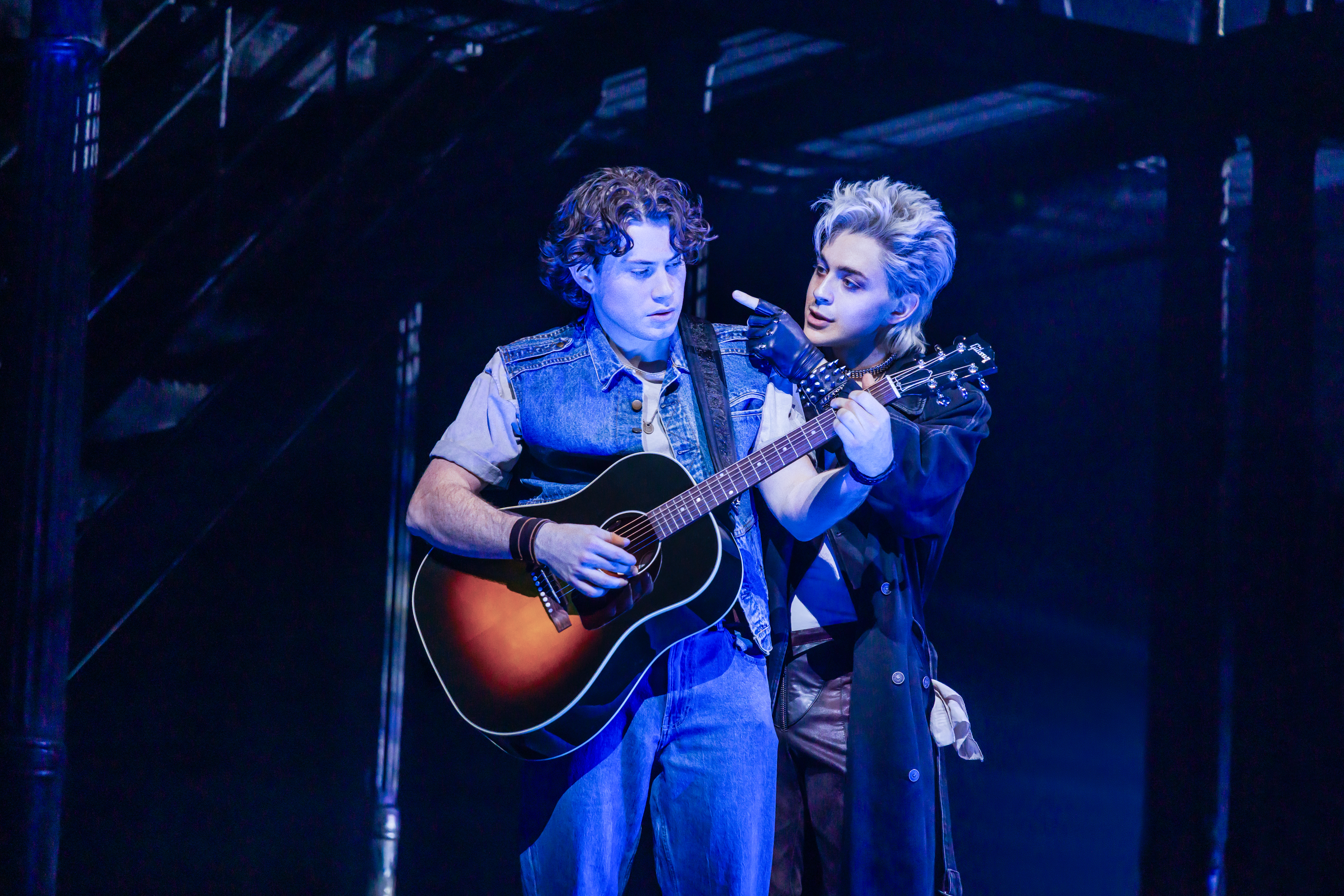 two men on stage with a guitar