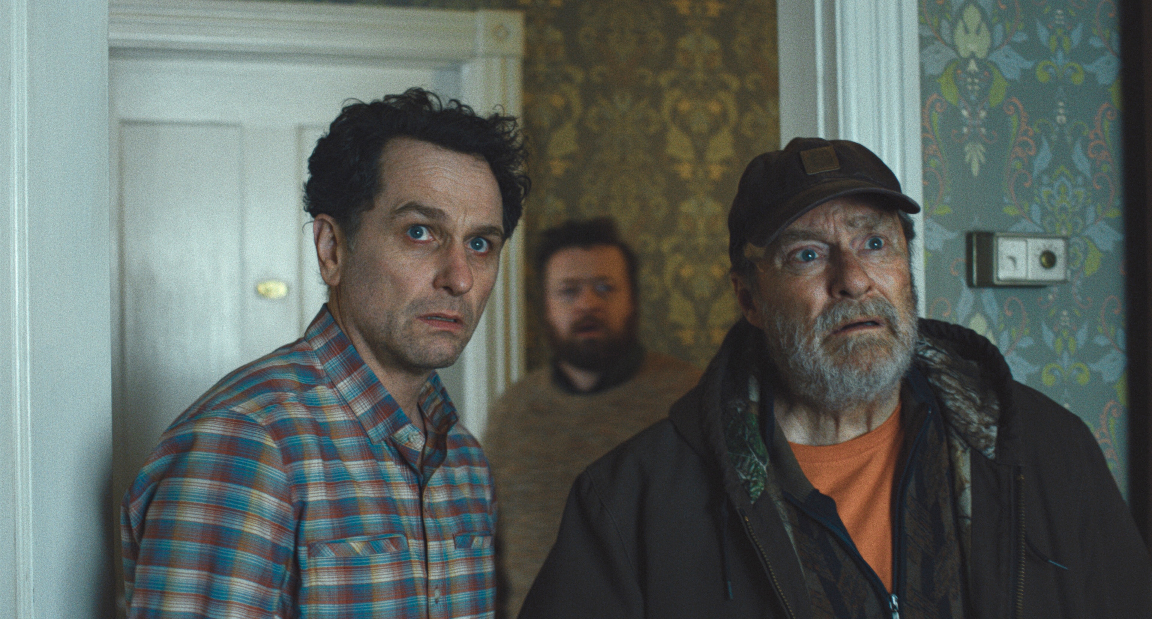 three men standing in a hall