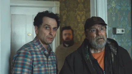 three men standing in a hall
