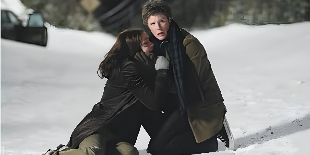 A man and woman crouching in the snow; a still from the movie Wind Chill