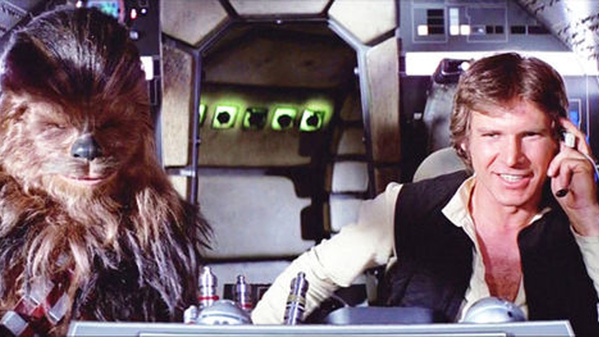 Hana Solo and Chewbecca sit in the cockpit of a spaceship in Star Wars