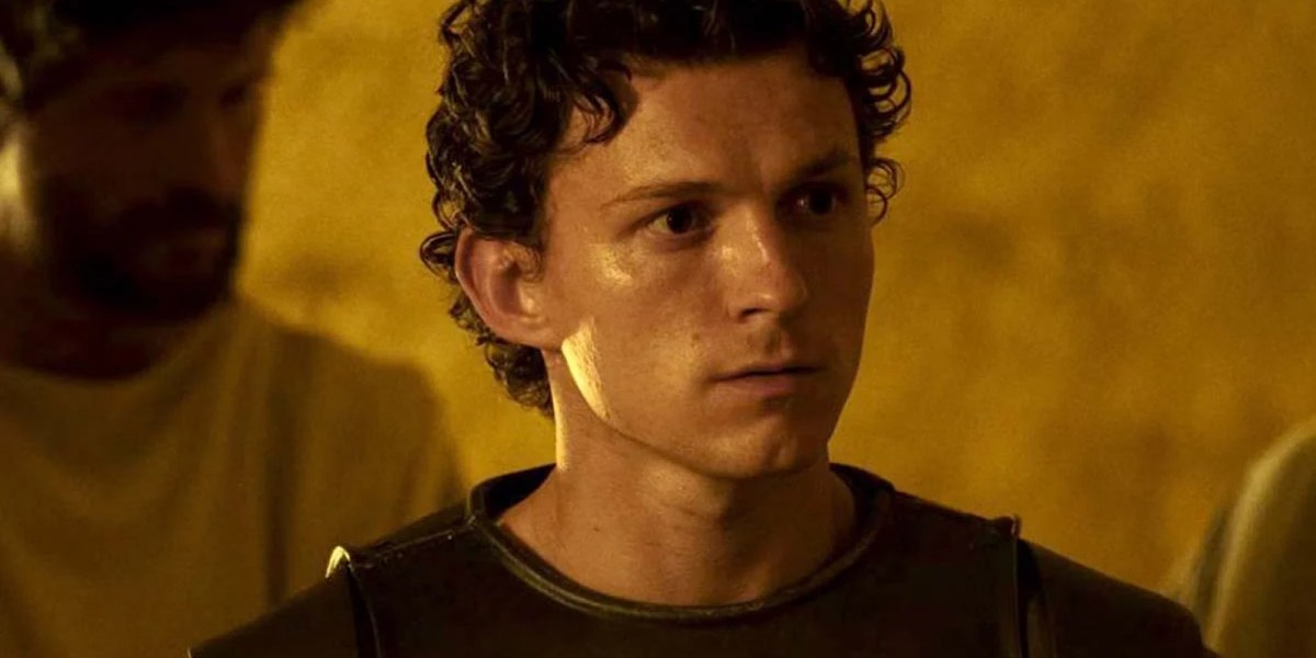 Man with short curly hair looking at something