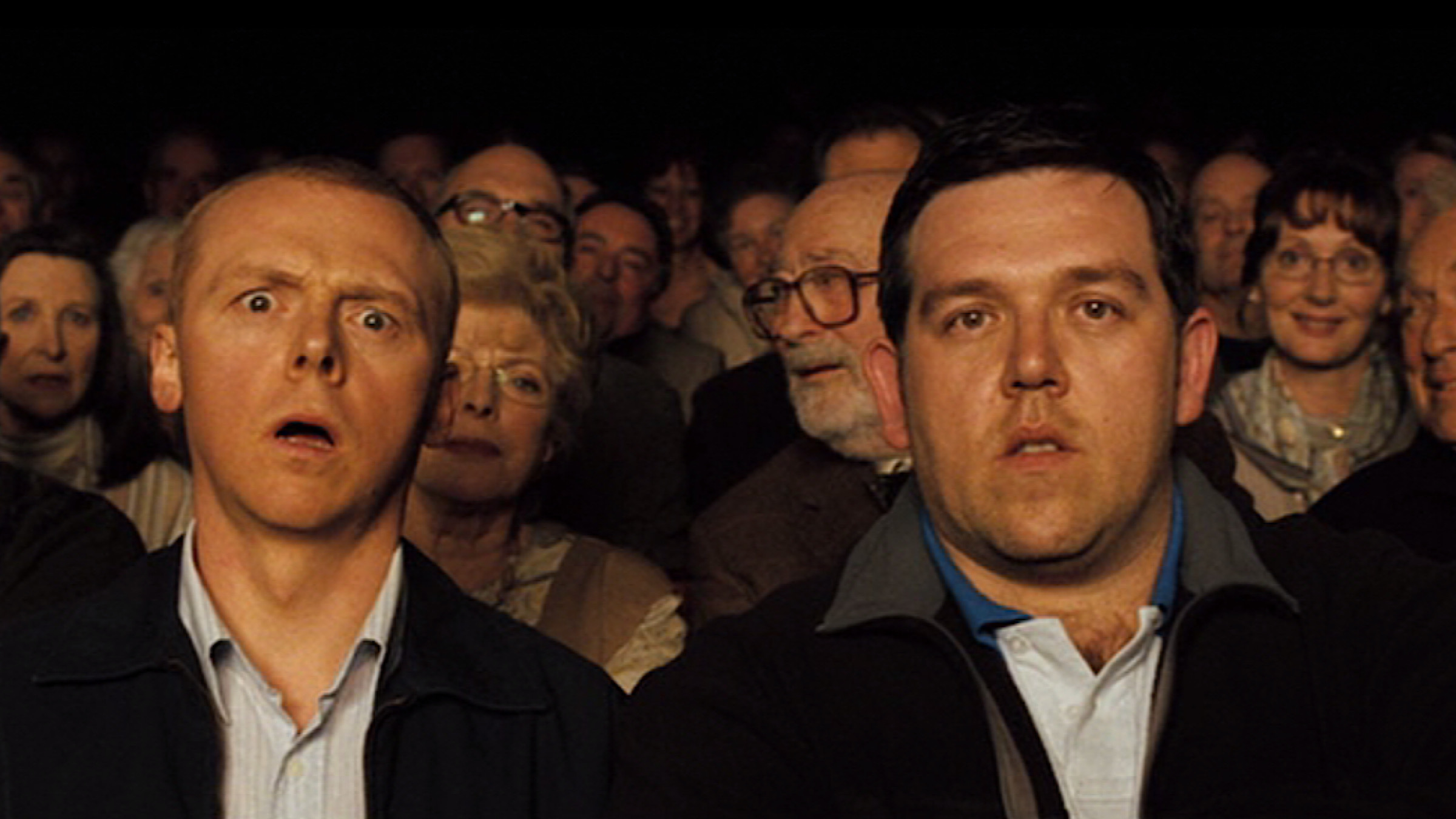 two men looking shocked and bemused surrounded by old people