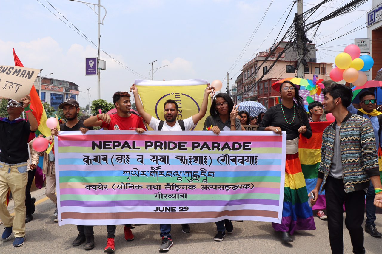 People marching and holding a Pride flag at the 2019 Nepal Pride Parade