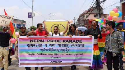People marching and holding a Pride flag at the 2019 Nepal Pride Parade