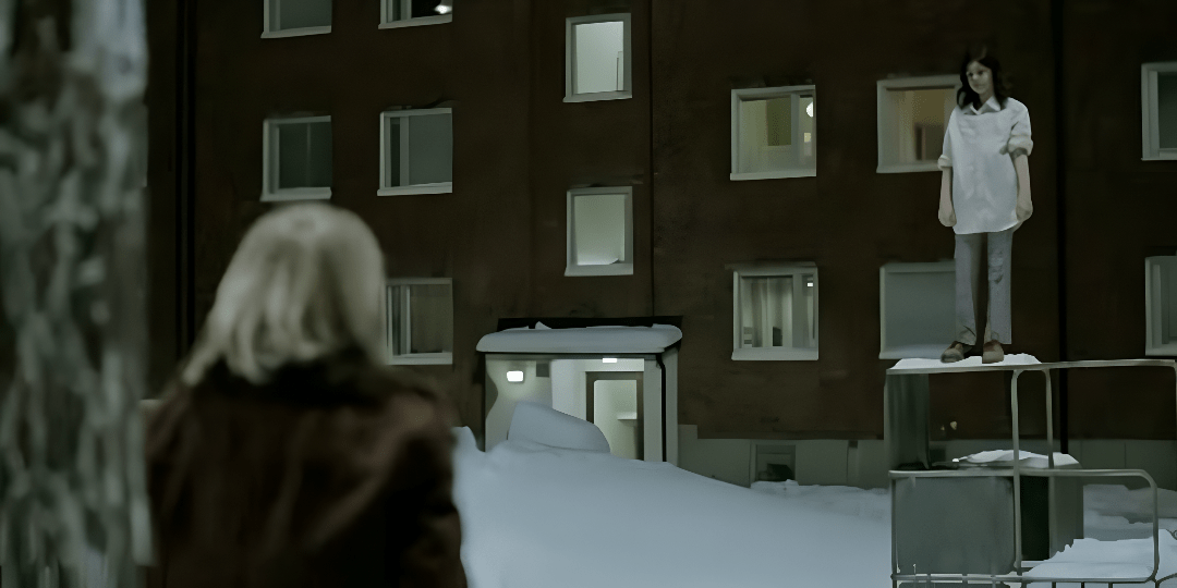 A still from the movie Let the Right One In with the back of a young blond boy facing a young dark-haired girl standing in front of an apartment